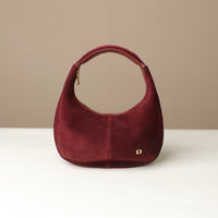red rounded suede leather danilos handbag on a beige background