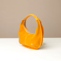 Yellow round suede leather danilos handbag on a beige background
