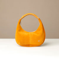 rounded Yellow suede leather danilos handbag on a beige background