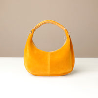 Yellow round suede leather danilos handbag on a beige background