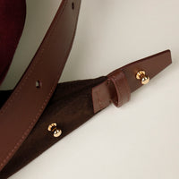 Brown leather strap with gold hardware on a neutral background, Mia Minimale, Danilos