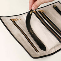 close-up view of the Danilos Leather jewelry organizer Mishka in black with gold accents in a beige background