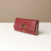 Front view of the Danilos Leather jewelry organizer Mishka in red with gold accents in a beige background