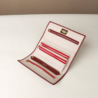 Front view of an open Danilos Leather jewelry organizer Mishka in red with gold zippers and organizers in a beige background
