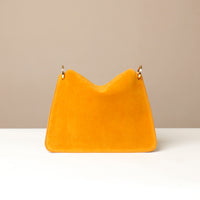 Back view of Mustard yellow handbag on a beige background