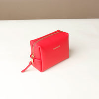 side view of a Red cosmetic bag mini emma danilos leather on a beige background