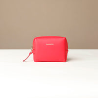 front view of a Red cosmetic bag mini emma danilos leather on a beige background