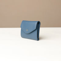 Blue wallet with a brand logo on a beige background