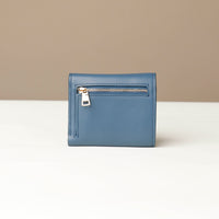 Blue wallet with a zipper on a white surface with a beige background
