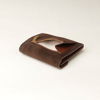 Brown suede danilos wallet with gold zipper opened on a light beige background