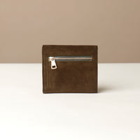 green suede danilos wallet with a zipper on a beige background