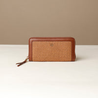 Brown woven wallet on a white surface with a beige background