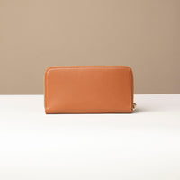 back view of a light brown Danilos wallet Carlota in a beige background