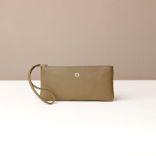 Brown wristlet clutch with a visible brand logo on a beige background