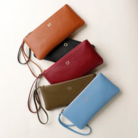 Five leather wallets in different colors on a light background